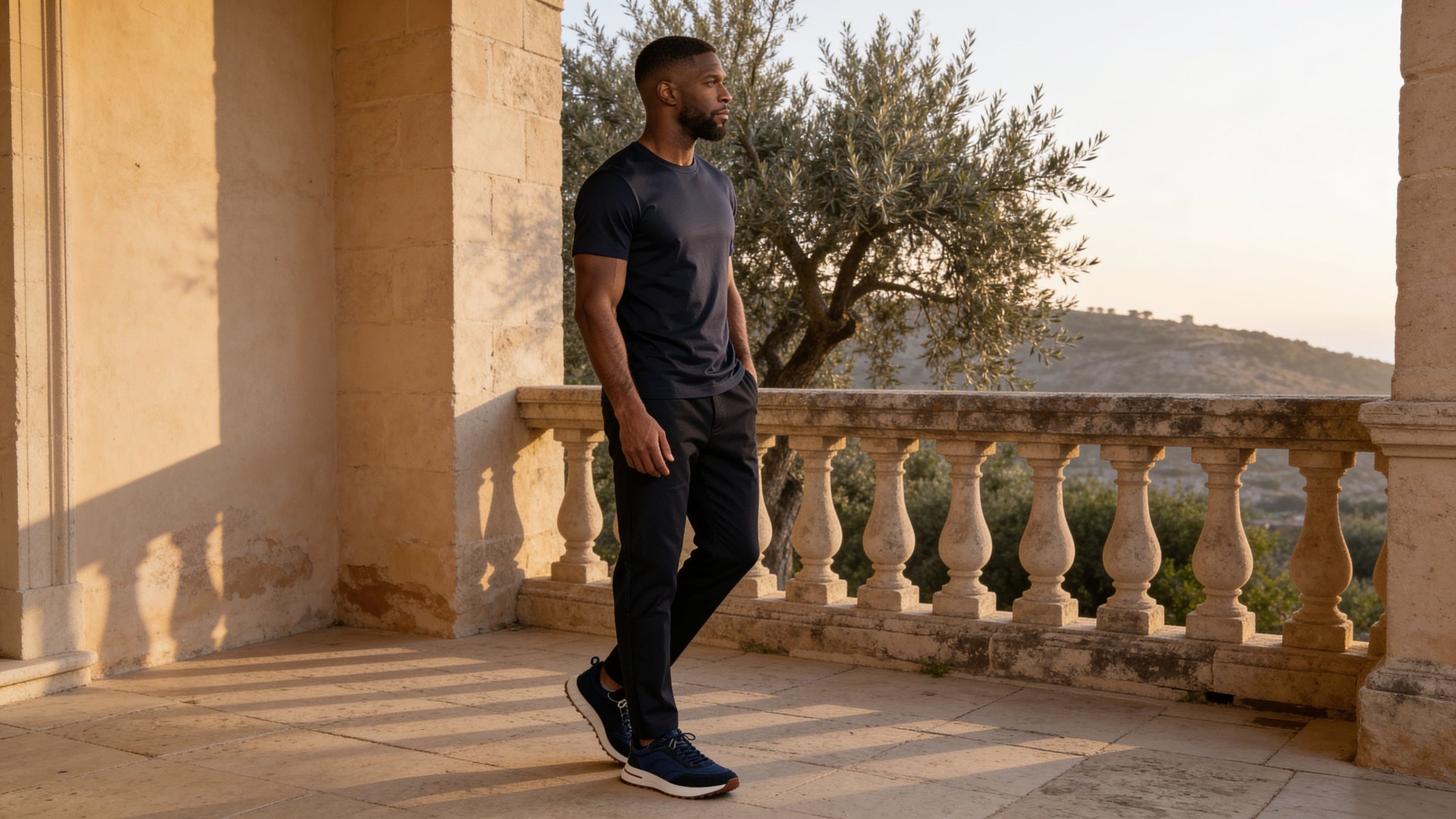 Lucci Monte navy T-shirt met zwarte pantalon op een Mediterraan terras bij zonsondergang